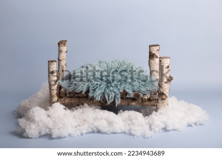 vintage wooden bed on a blue background with a blue fur bedspread stands on a cloud. bed for newborns. background design for newborns.