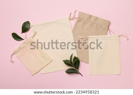 Small eco sacks with green leaves color on background. Top view.