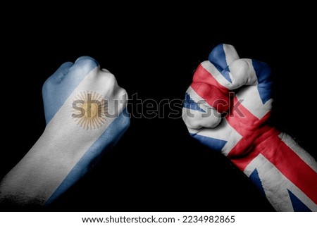 ARGENTINA VS ENGLAND. Strong men hands painted country flags in fighting signal black background. Countries with social, economic, political, cultural, territorial, sports, financial conflicts.