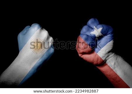 ARGENTINA VS CHILE. Strong men hands painted country flags in fighting signal black background. Countries with social, economic, political, cultural, territorial, sports, financial conflicts.