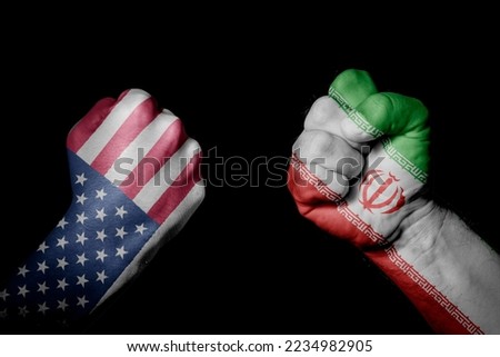 USA VS IR IRAN. Strong men hands painted country flags in fighting signal black background. Countries with social, economic, political, cultural, territorial, sports, financial conflicts. Royalty-Free Stock Photo #2234982905