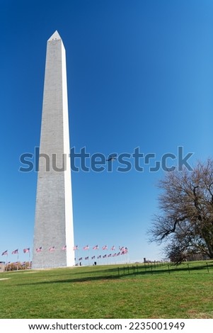 washington dc. A helicopter flies over George Washington's monument on a sunny day with a blue cloudless sky background.