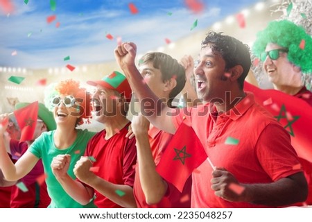 Morocco football supporter on stadium. Moroccan fans on soccer pitch watching team play. Group of supporters with flag and national jersey cheering for Morocco. Championship game. Royalty-Free Stock Photo #2235048257