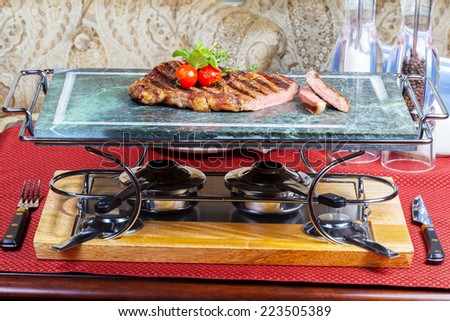 preparation of grilled meat with tomatoes on a marble tray