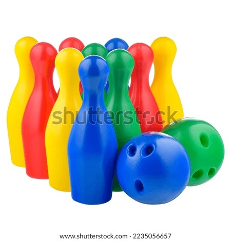 Multicolored bowling pins and a bowling ball isolated on a white background. Children's plastic bowling set, close-up. Active sports games, children's leisure.