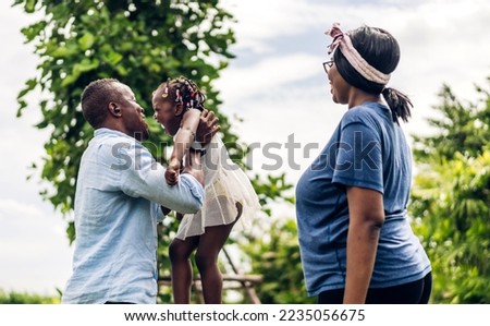 Portrait of enjoy happy family african american father and mother with little african girl child smiling and play having fun moments good time in room at home