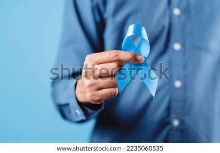 men hands showing Blue ribbon for supporting people living and illness, Colon cancer, Colorectal cancer, Child Abuse awareness, world diabetes day, International Men's Day Royalty-Free Stock Photo #2235060535