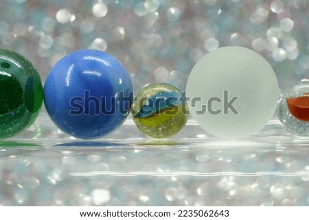 Glass balls and colorful marbles against a light blurred background
