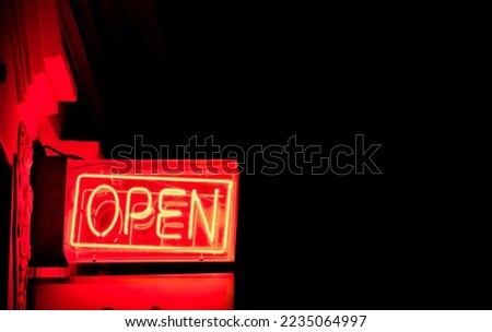 neon sign with the word open. street sign. urban sign illuminating at night. bar illumination. rock music venue. 