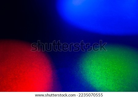 Red, blue and green light at black surface...