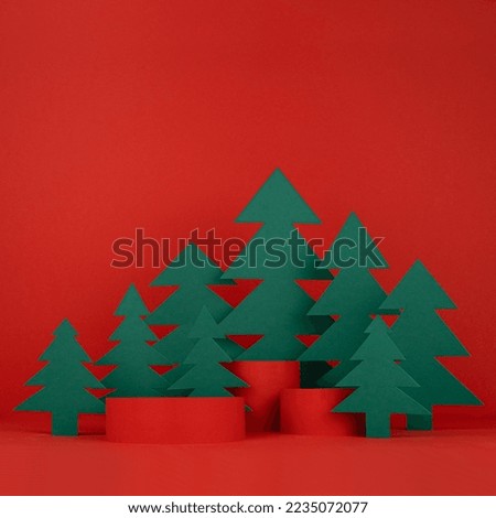 Festive Christmas background with three red cylinder podiums mockup, green paper spruces for presentation cosmetic product, gifts, goods, copy space, square. New Year template for advertising.
