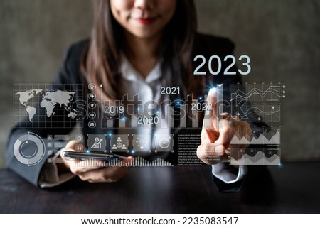 Businesswoman with a modern visual screen 2023 global network connection Graph analyzing financial growth and business planning concept