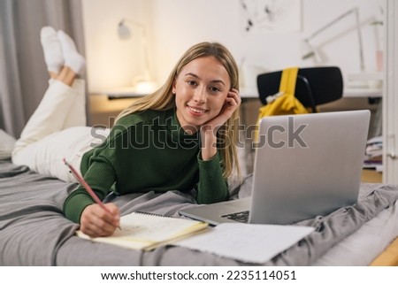 College student studies on the bed for the exam