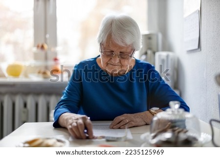 Elderly woman filling out financial statements
 Royalty-Free Stock Photo #2235125969