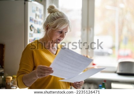Senior woman filling out financial statements
 Royalty-Free Stock Photo #2235126471