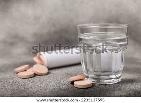 An effervescent vitamin tablet drops and dissolves in a glass of water on a black marble background. The concept of health. Medicine concept. Place for text.