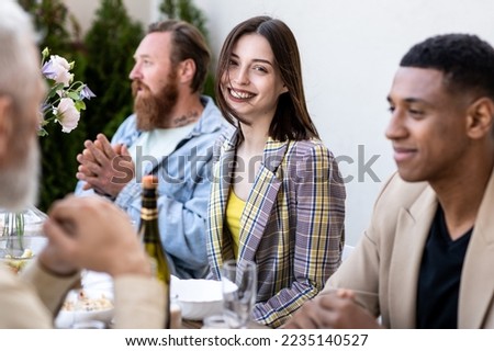 Storytelling image of a multiethnic group of people dining on a rooftop. Family and friends make a reunion at home