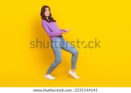 Full length profile portrait of hardworking person arms hold heavy empty space object isolated on yellow color background Royalty-Free Stock Photo #2235144141