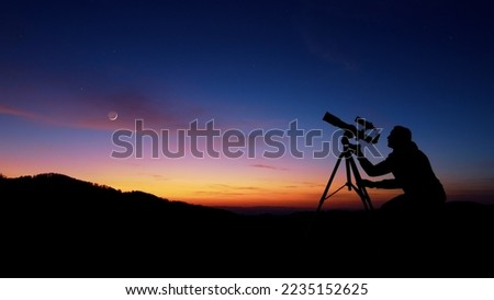 Man with astronomy telescope looking at the night sky, stars, planets, Moon and shooting stars. Royalty-Free Stock Photo #2235152625