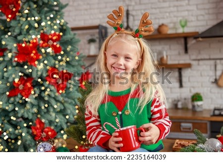 Happy girl opens a gift box for the holiday of Christmas, Happy New Year, a magical moment of receiving a gift, Christmas tree lights, holiday decor, new year 2023.