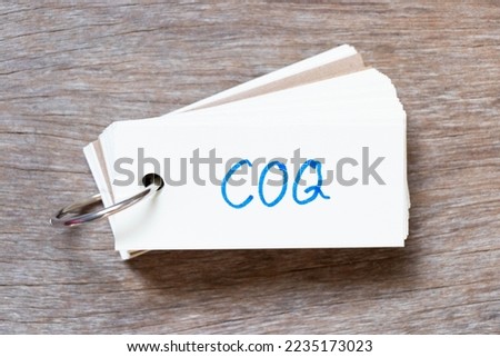 Flash card with handwriting in word COQ (Abbreviation of cost of quality) on wood background