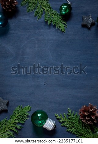 Christmas or New Year navy blue stylish frame on the wooden background. Top view winter holiday greeting card. Copy space