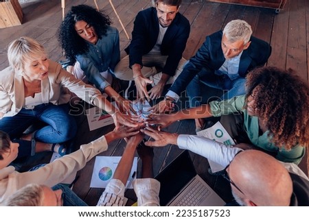group of people working in team sitting on circle on floor with positive vibes