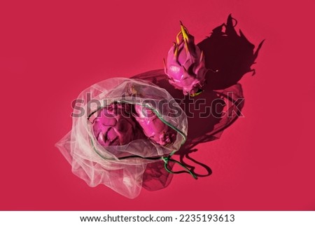 Dragon fruits in eco bag on bright magenta background. Top view.