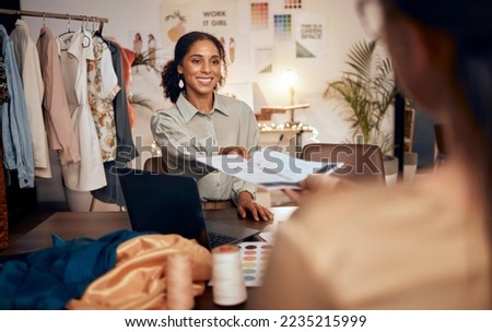 Fashion, black woman designer and client in creative studio for consulting on custom clothing designs. Fabric, design and woman with customer, happy smile and portfolio documents for sales at desk. Royalty-Free Stock Photo #2235215999