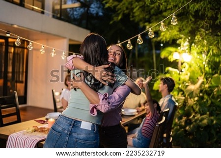 Young Asian woman visit the family during party outdoors in the garden. Attractive diverse group of people having dinner, eating foods, celebrate weekend reunion gathered together at the dining table Royalty-Free Stock Photo #2235232719