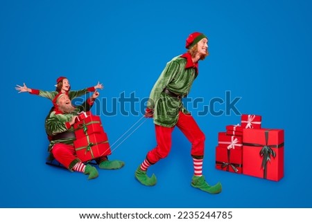 Full size photo of santa workers people sled with giftboxes wear new year look isolated on red background
