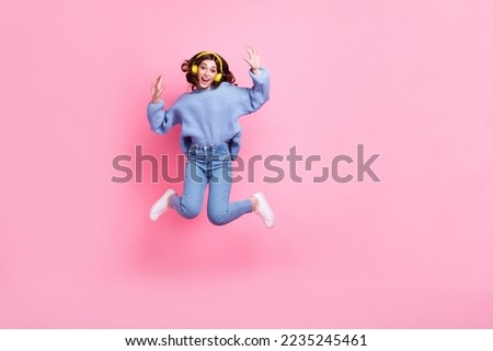 Full body portrait of cheerful active lady jumping listen new single rejoice isolated on pink color background