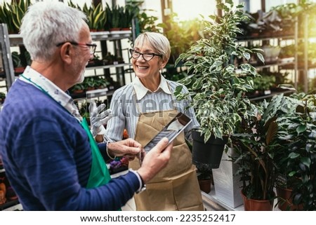 Elderly couple in own flower shop. Concept of small business. Royalty-Free Stock Photo #2235252417