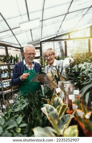 Elderly couple in own flower shop. Concept of small business.