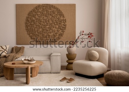Living room interior with mock up poster frame, beige sofa, round wooden coffee table, rug, pouf, vase with rowan, rounded shapes armchair, braided plaid and personal accessories. Home decor. Template Royalty-Free Stock Photo #2235256225