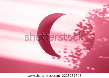 Viva Magenta. Color of the year 2023. Podium for cosmetic. Abstract minimal geometrical form. Cylinder, Floral sunlight shadow. Scene to show products. Showcase, display case. Flat lay, top view