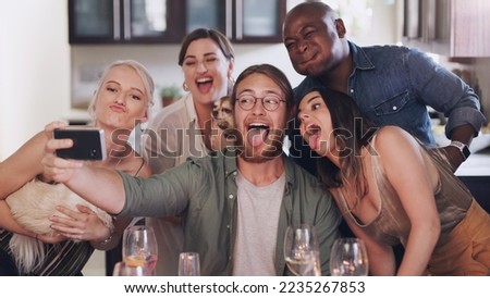 Friends, selfie and silly pose during dinner party at home to celebrate new years eve together. Phone, photo and funny face diverse group of people posing for a mobile picture during lunch
