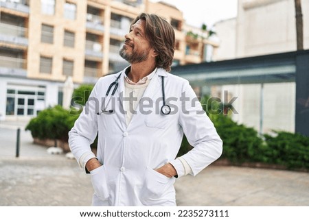 Middle age man doctor smiling confident standing at street