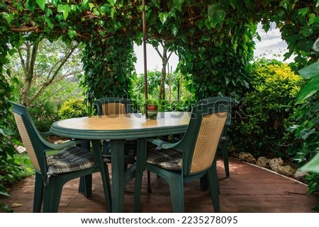 Table and chairs in a green gazebo