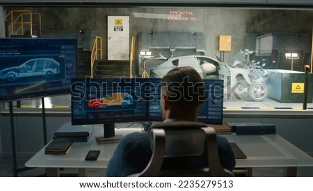 An engineer in a crash test lab uses a car crash test system to simulate a traffic accident, to obtain the safety parameters of an eco-friendly cutting edge electric vehicle being developed. Royalty-Free Stock Photo #2235279513