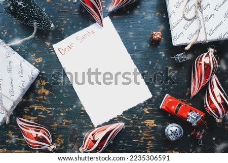 Dear Santa letter written with crayons with Christmas presents, ornaments and vintage toy truck over rustic background. Overhead table top view. Copy space available.