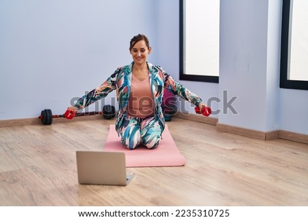Middle age woman smiling confident having online training lesson at sport center