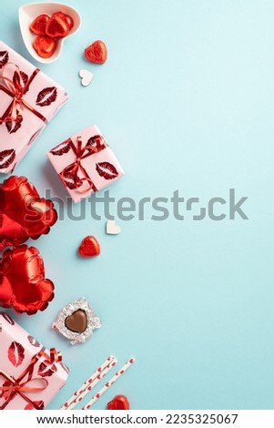 Valentine's Day concept. Top view vertical photo of gift boxes heart shaped balloons saucer with chocolate candies and straws on isolated pastel blue background with empty space