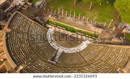 Aerial view on the Roman theatre of Ostia Antica, a large archaeological site, close to the modern town of Ostia. The ancient Roman Amphitheater is located in Rome, Italy. Royalty-Free Stock Photo #2235326693