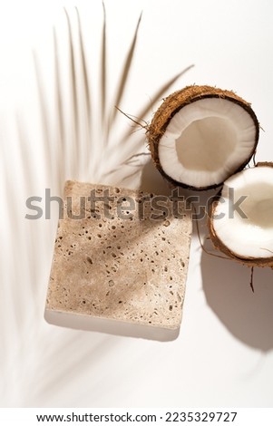Coconut beauty skincare scene for cosmetic product presentation made with travertine tile mockup podium on white background, view above. Vertical photography.