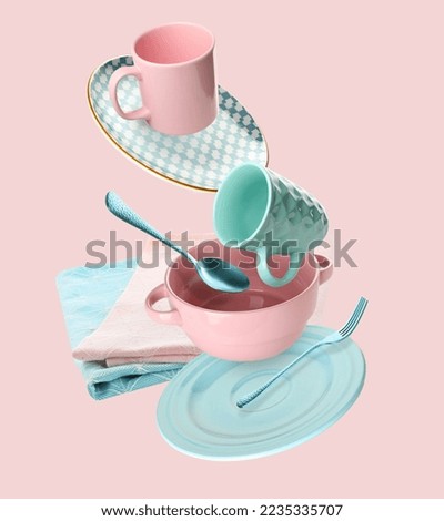 Flying clean dishes, napkins and cutlery on pink background Royalty-Free Stock Photo #2235335707