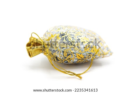 Celebratory gift wrapping in openwork fabric with golden ribbon isolated on white background.