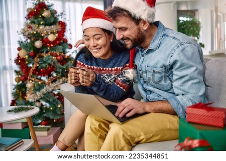 Young couple shopping online with credit card at home for Christmas
