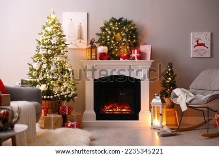 Stylish living room interior with beautiful fireplace, Christmas tree and other decorations