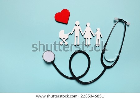 Figures of family near stethoscope and heart on light blue background, flat lay. Insurance concept